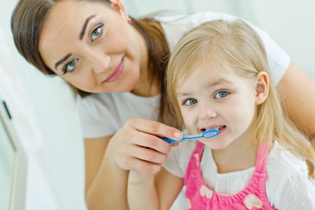 Mom and Daughter brushing their teeth - Pediatric Dentist in Macon, GA