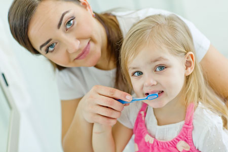 Mom and Daughter brushing their teeth - Pediatric Dentist in Macon, GA